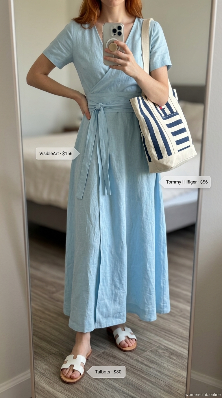 Azure blue linen maxi wrap dress outfit 2026 for vacation. Styled with striped tote and white slide sandals.