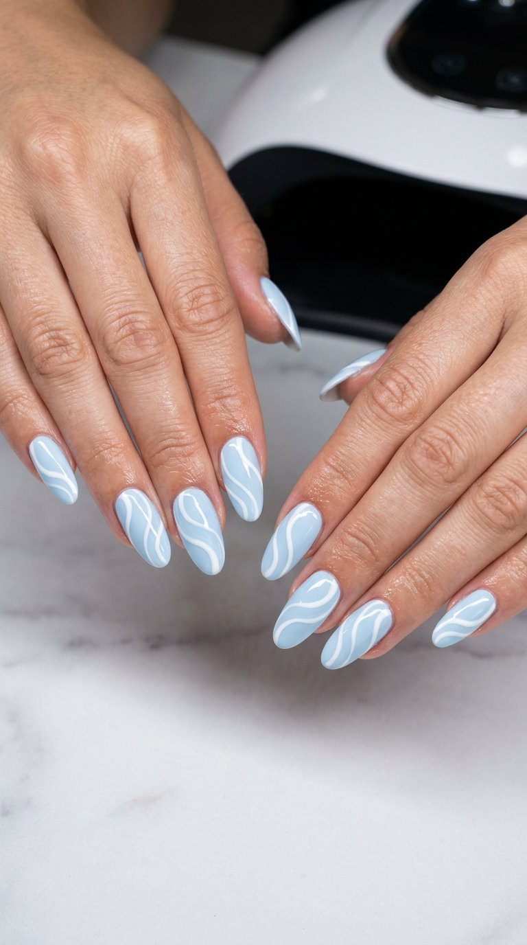 Pale blue swirl art oval summer nails 2026 for all skin tones, ideal for festivals and casual summer vibes.