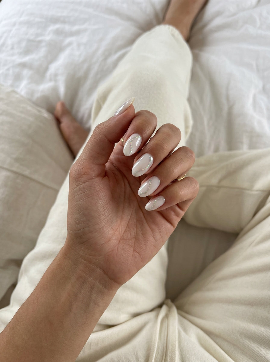 Holographic Swirl Nails 2026: Whimsical & Dreamy Milky white almond nails with holographic swirls for a whimsical vacation look. Summer vibes nails 2026.