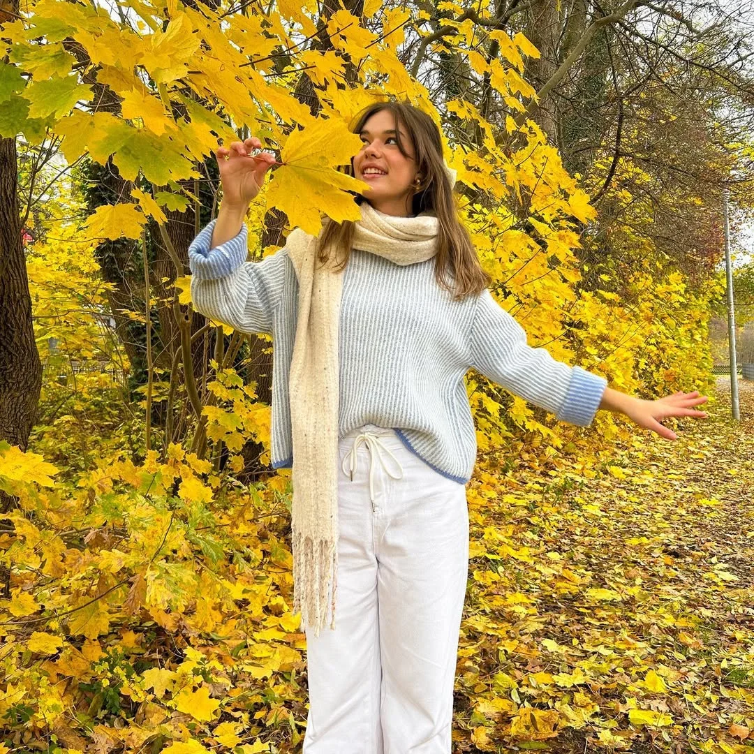 Early fall outfits ideas 2026 Soft Blue Knitwear Against Golden Autumn Leaves