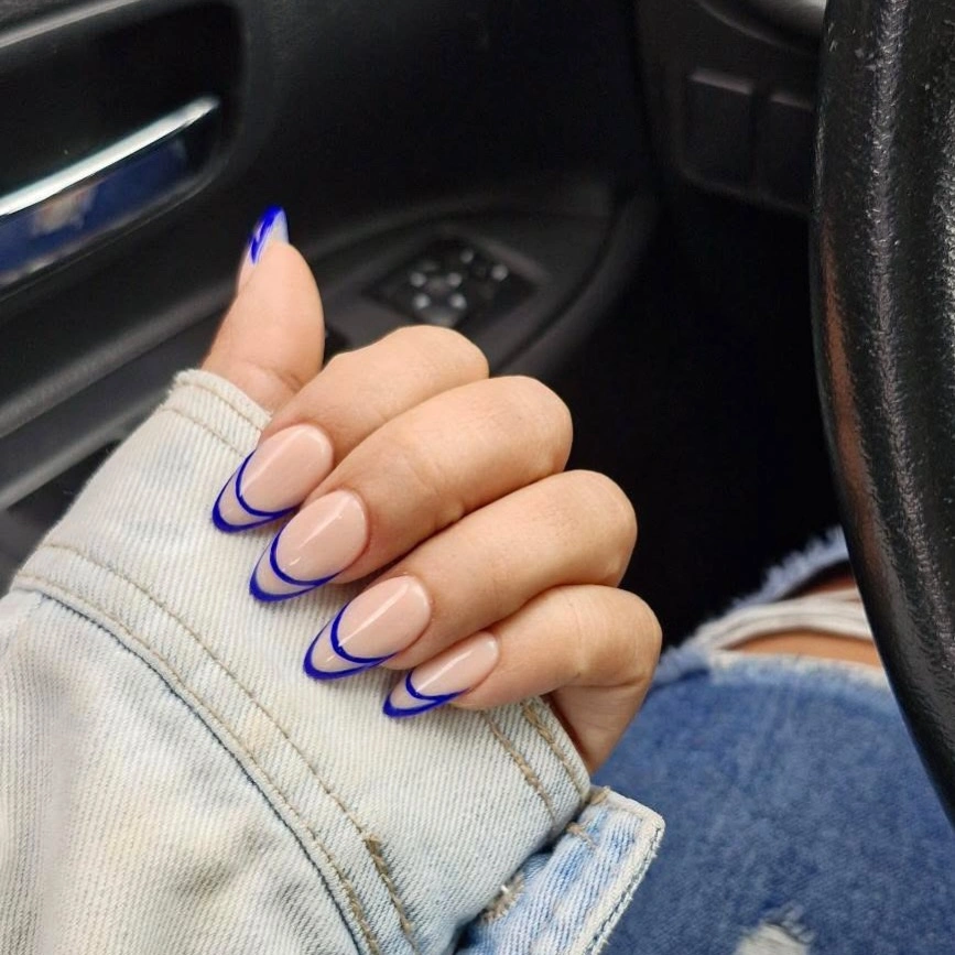 nude almond tips with blue outlined French edges