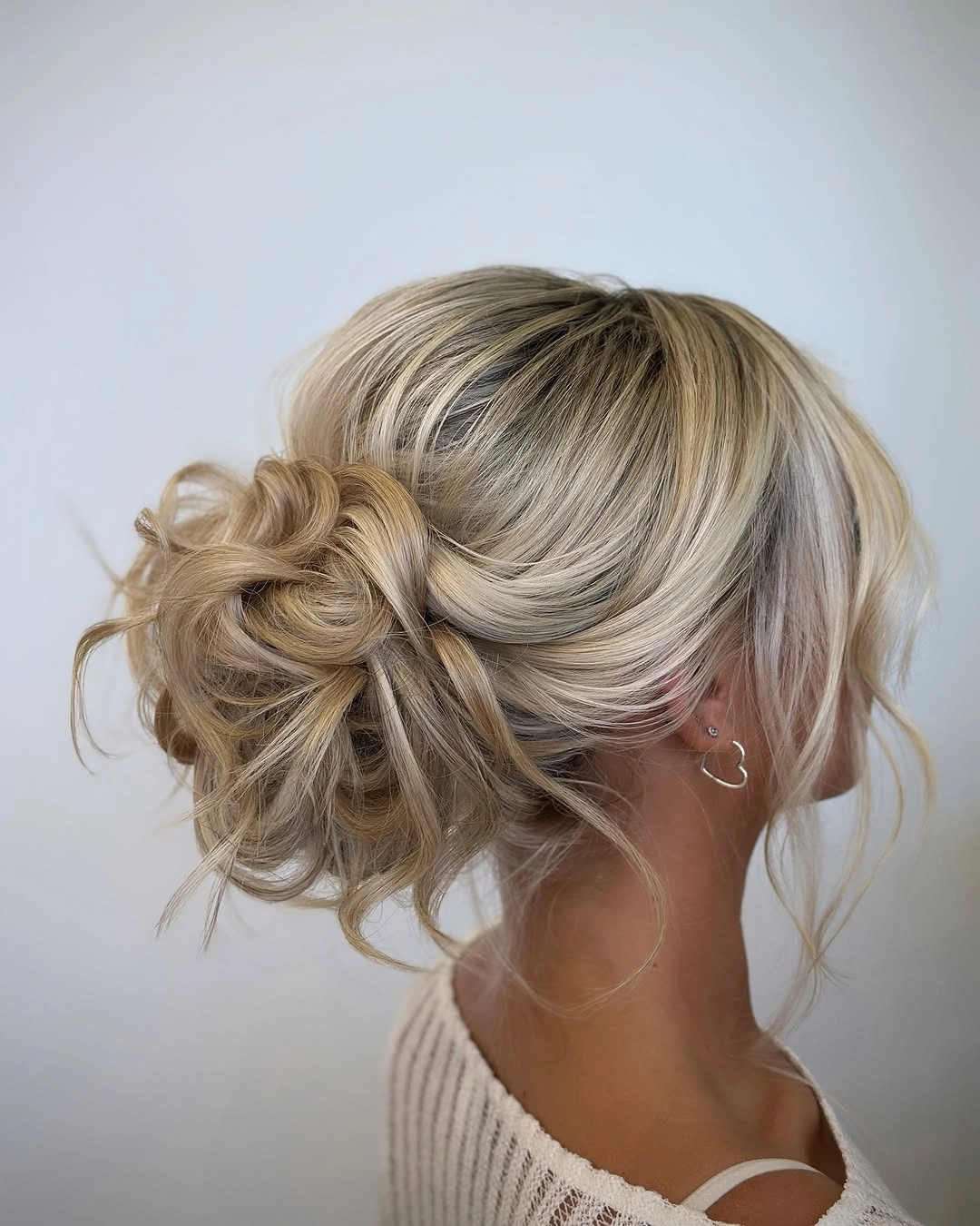 Fall hairstyles for office 2026 Relaxed Low Textured Bun with Soft Blonde Dimension