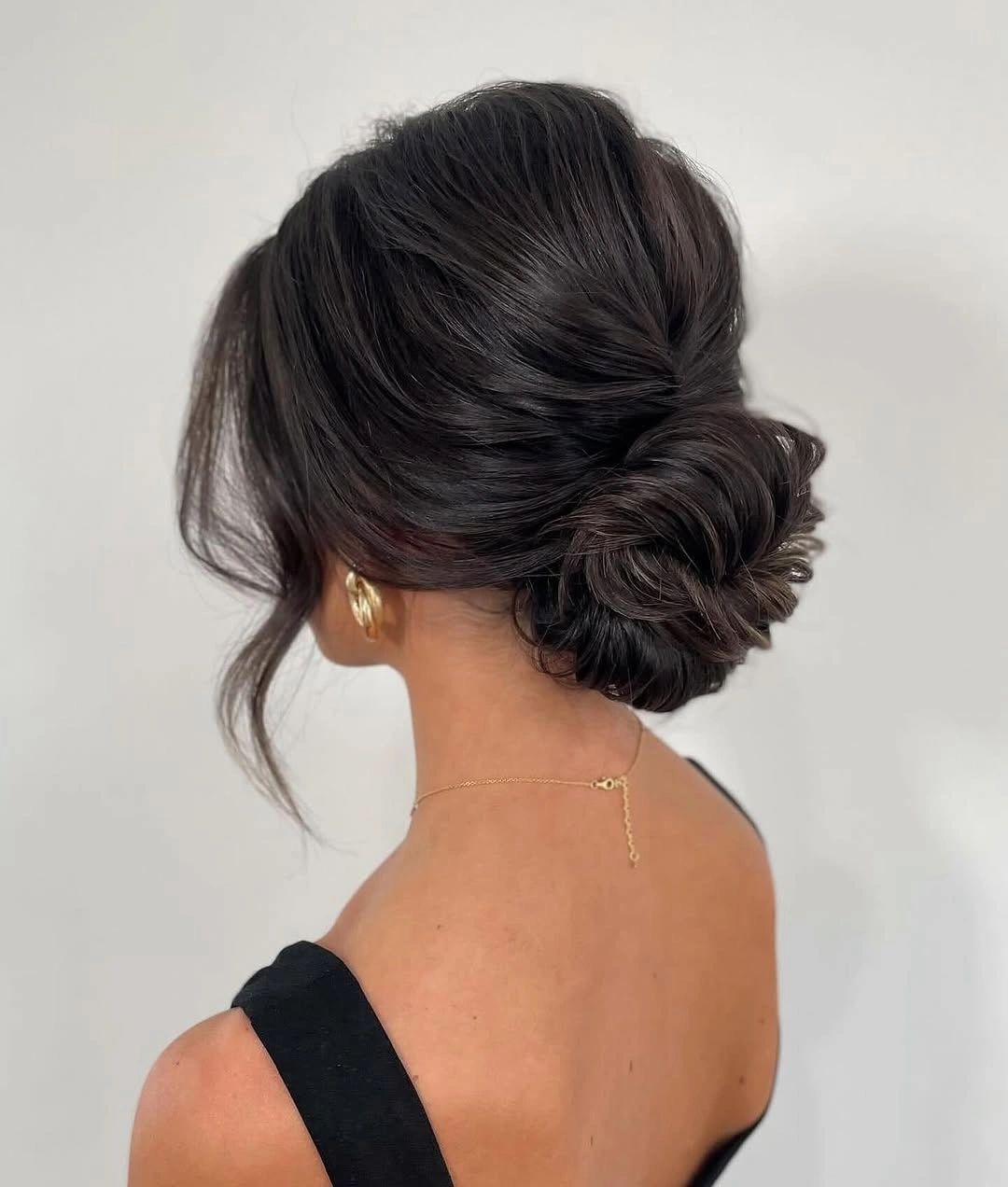 Fall hairstyles for office 2026 Glossy Brunette Twisted Low Bun with Classic Sophistication