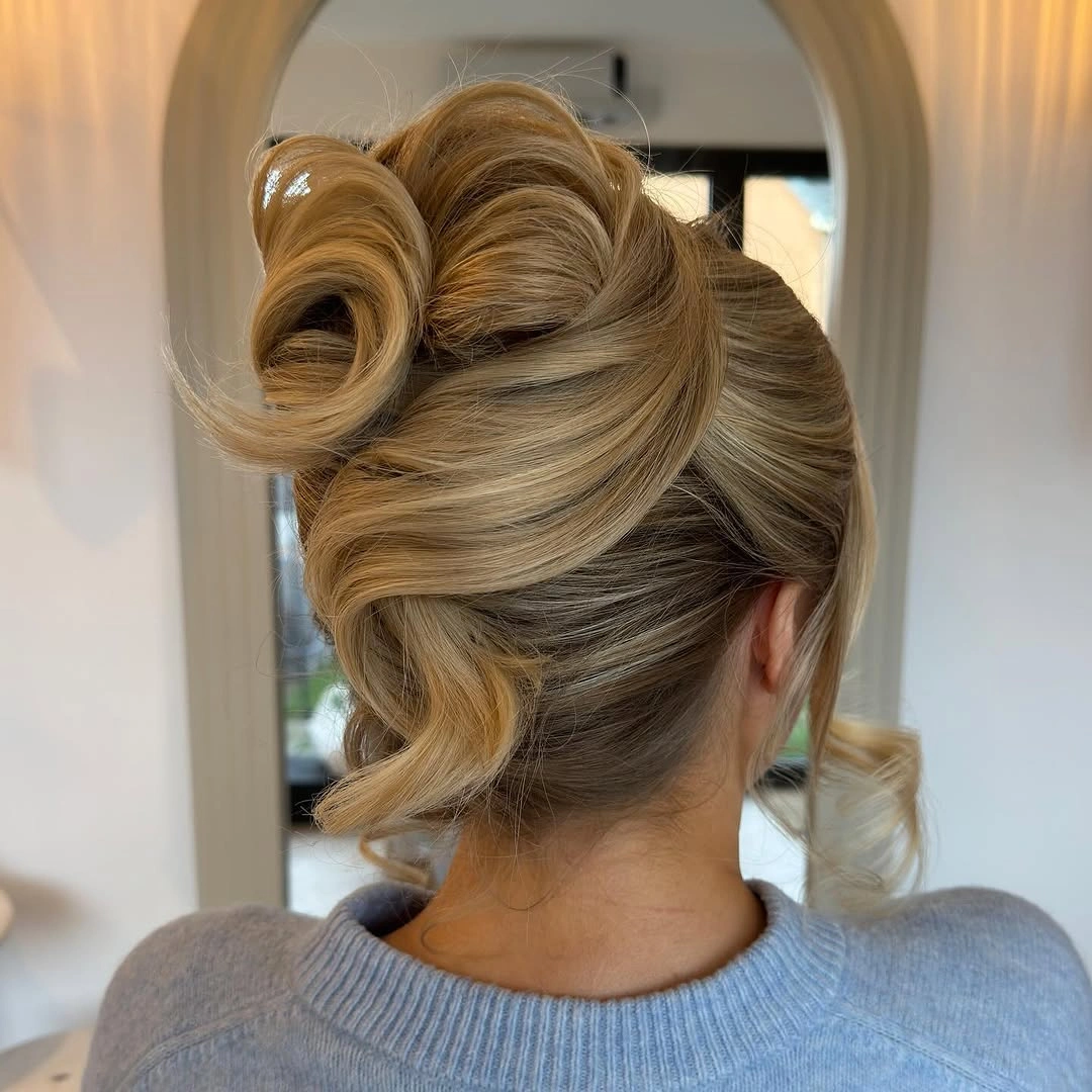 Fall hairstyles for wedding guests 2026 Statement Blonde Updo with Oversized Sculptural Rolls