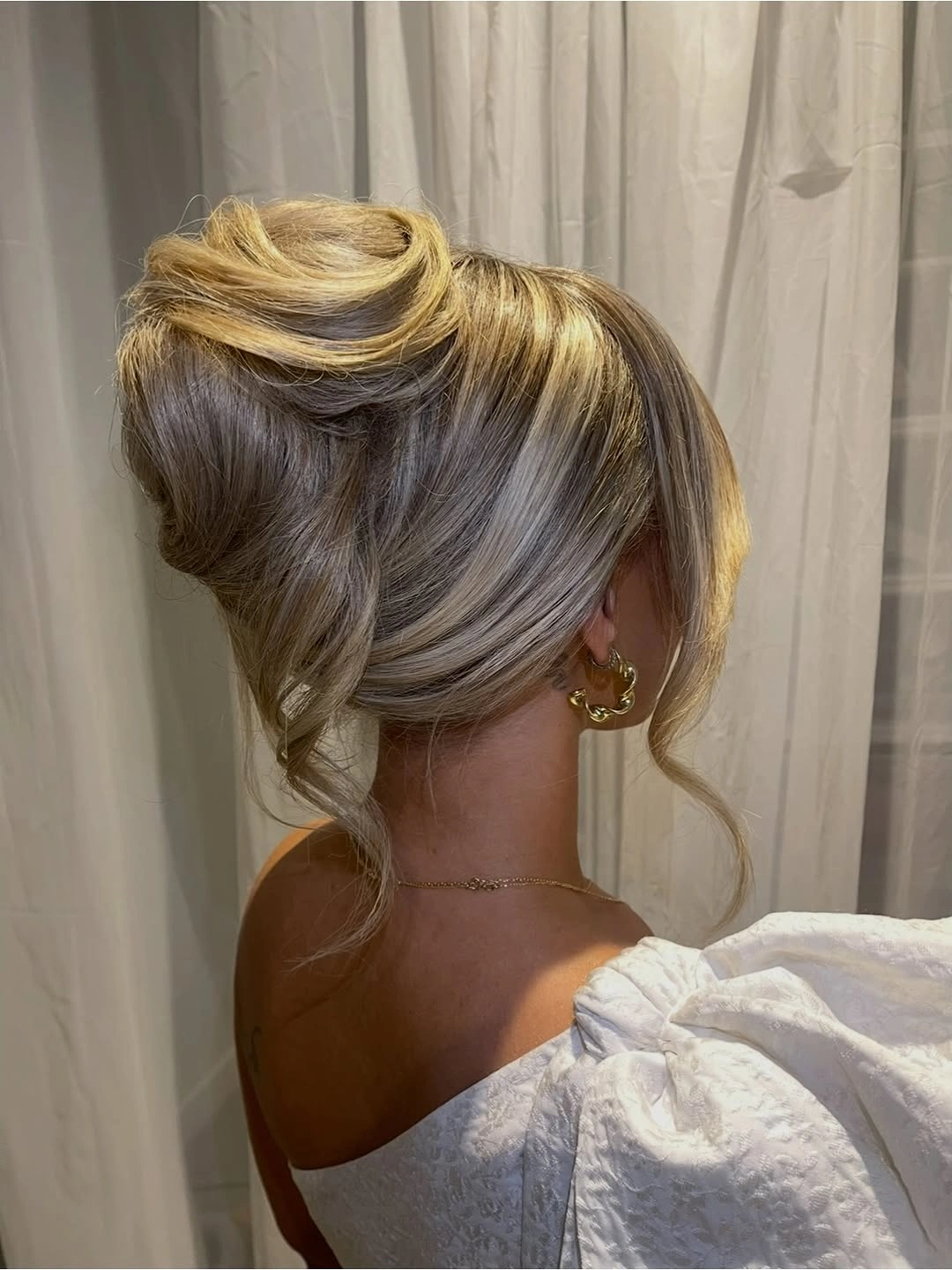Fall hairstyles for wedding guests 2026 Soft French Twist with Face-Framing Blonde Layers