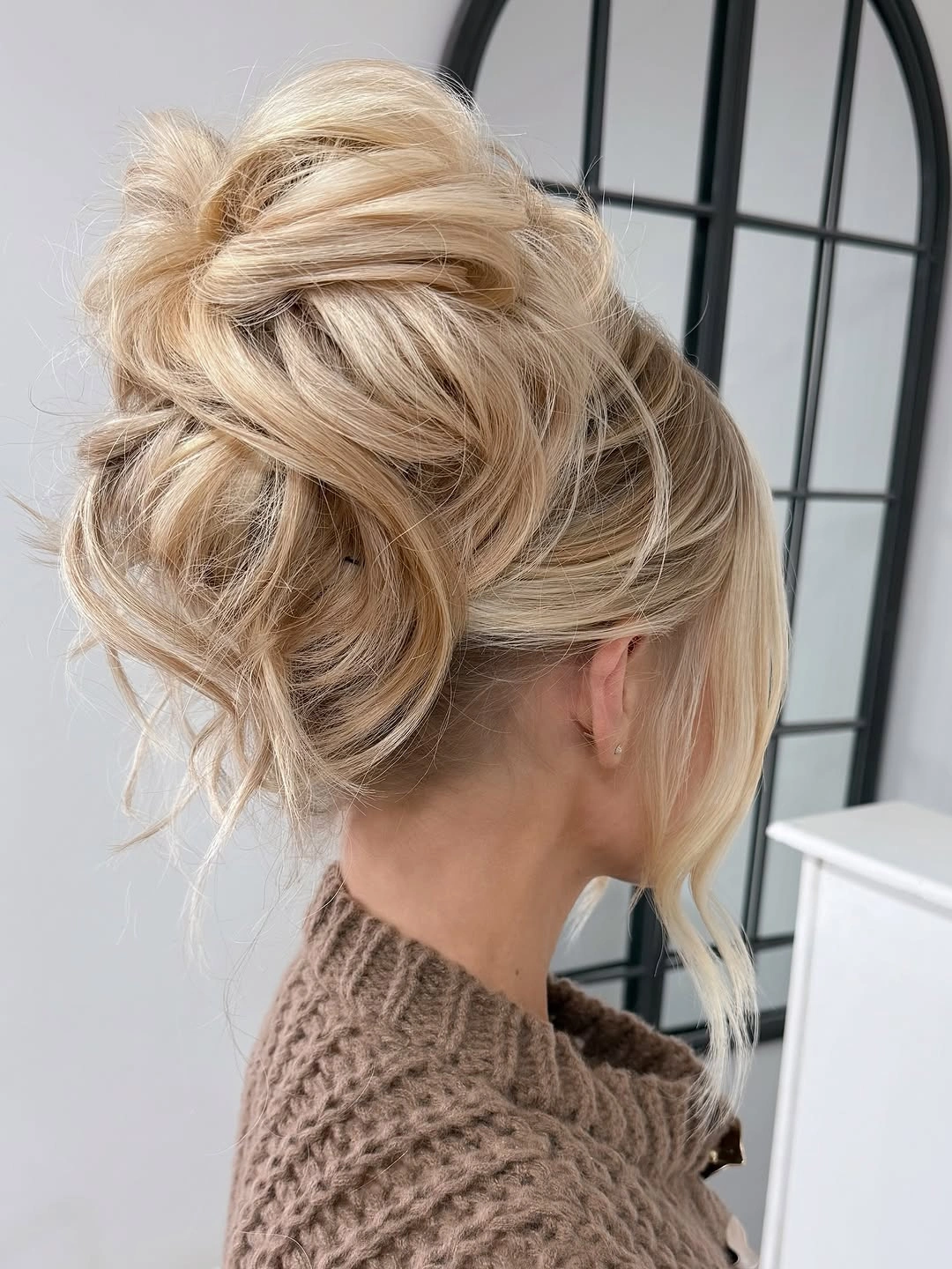 Fall hairstyles for wedding guests 2026 Textured Voluminous Blonde Updo with Loose Movement