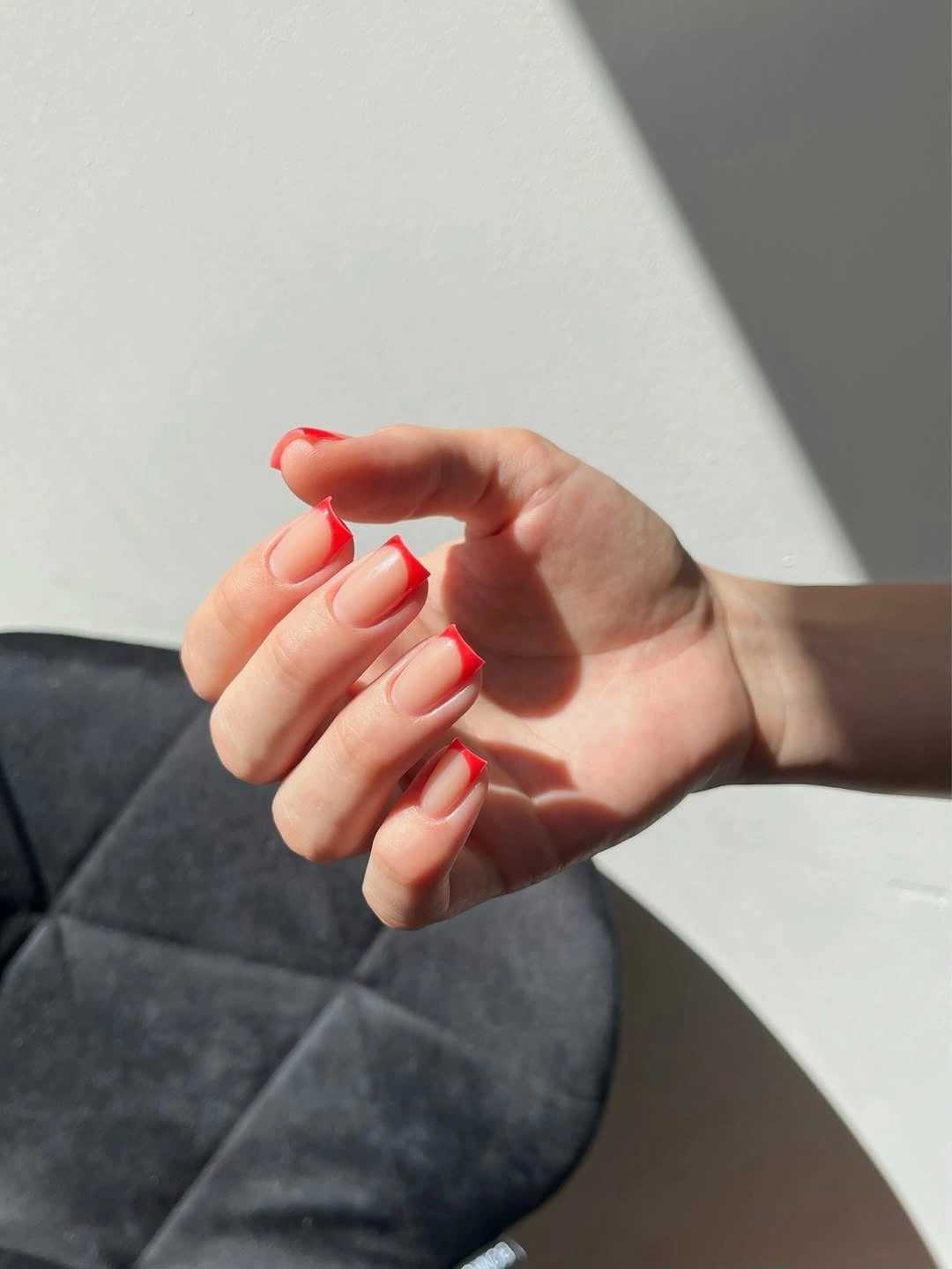 bare pink and bright red medium square nails with angled French corner tips