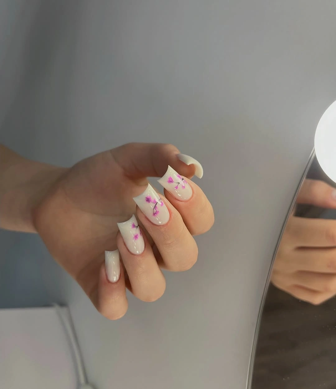milky white and purple medium square with flared white tips nails with purple floral stems over white tips