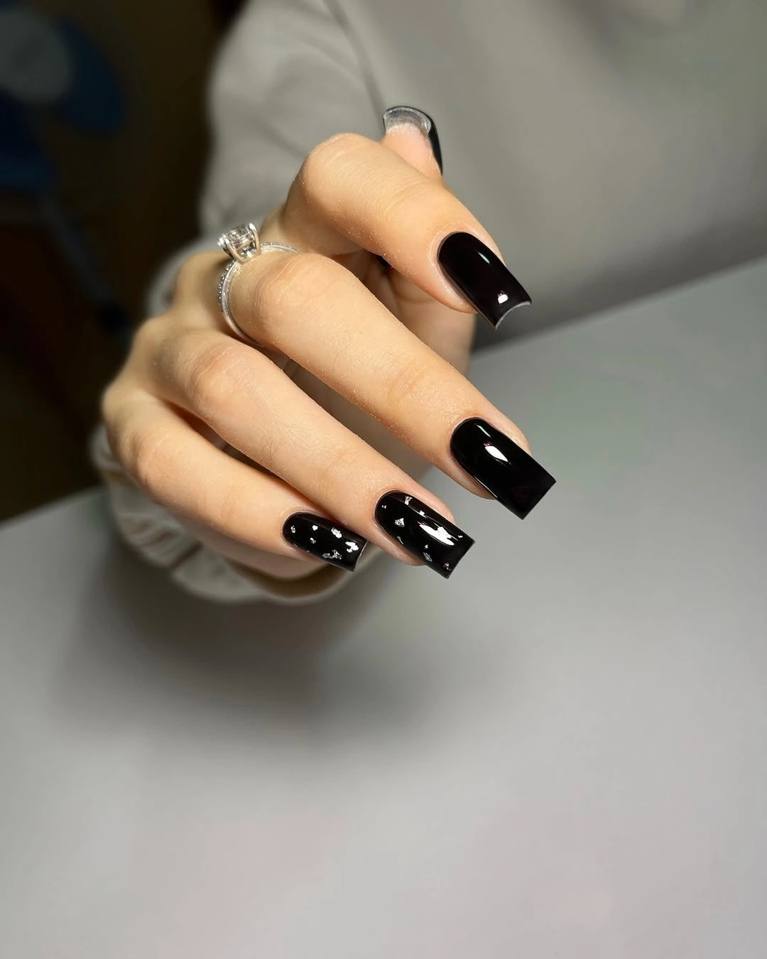 black with small silver flecks long square nails with solid black plus scattered fleck accents