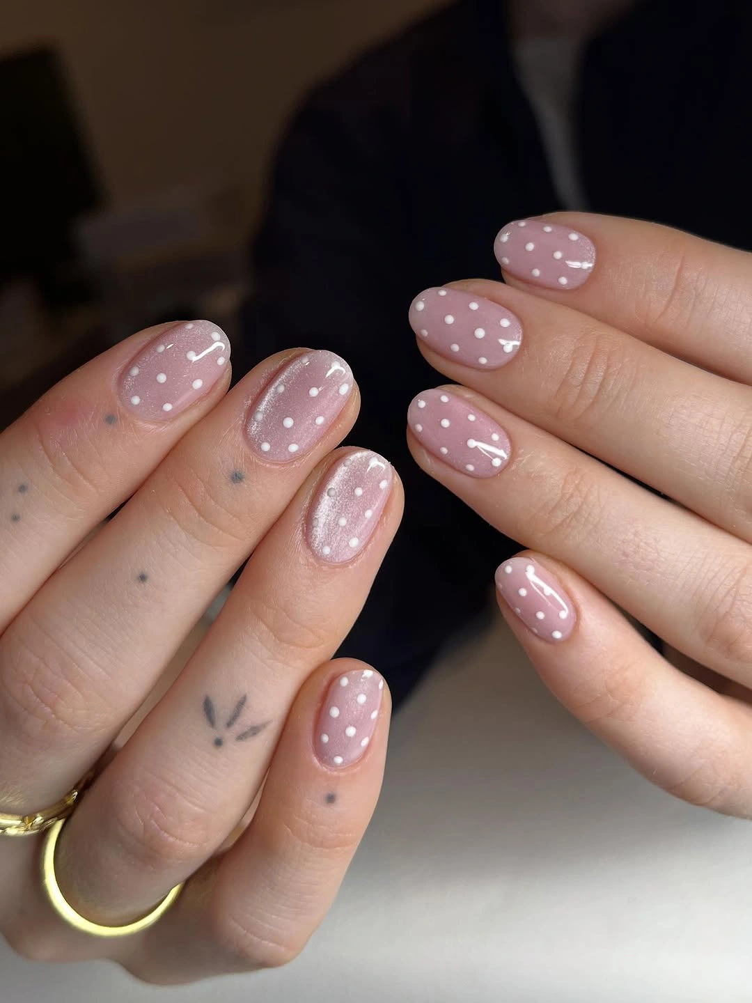 sheer rosy pink and white short to medium rounded oval nails with even polka dots