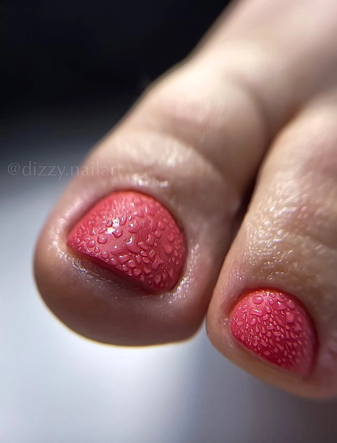 coral pedicure with dewy textured nail surface