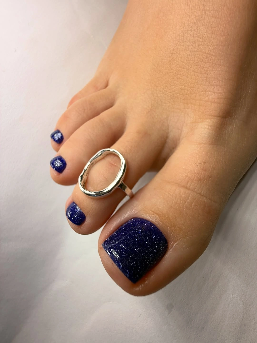 navy sparkle pedicure with silver toe ring