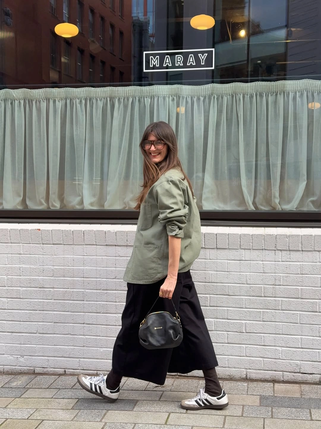 September fashion trends 2026 Olive Shirt With Black Skirt And Sneakers