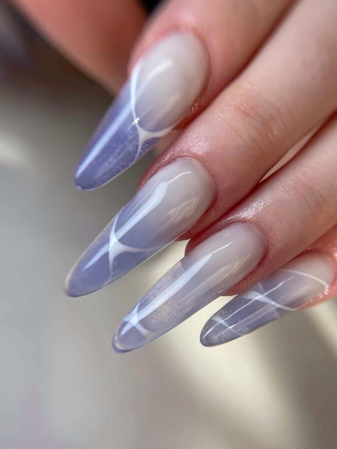 Long translucent lavender nails with fine white lines