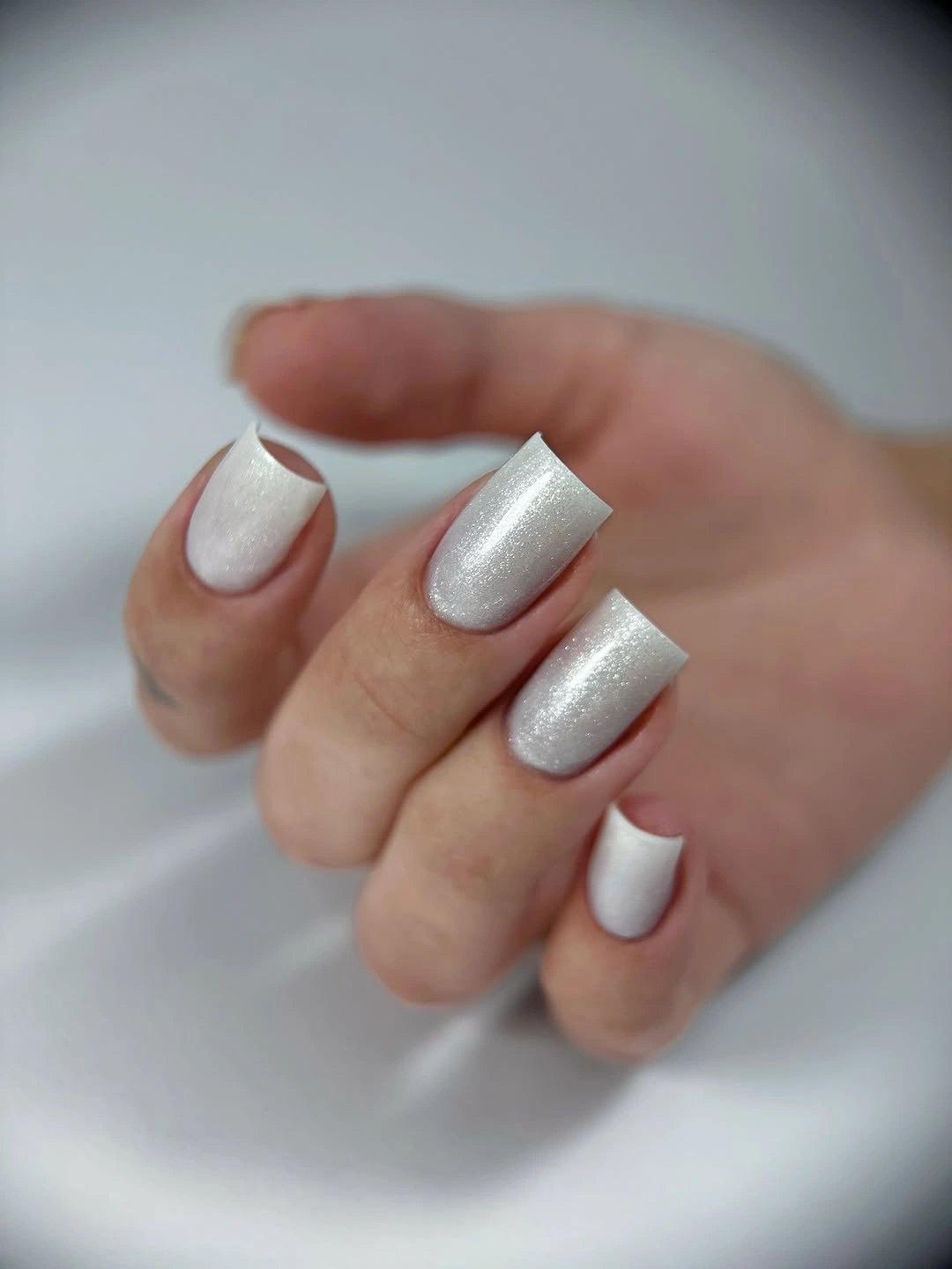 Short square white nails with a softly textured surface