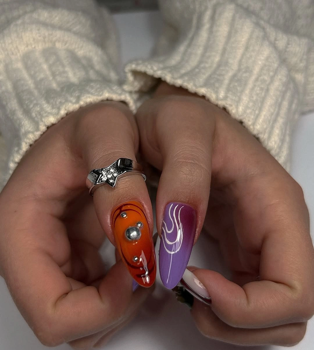 Long orange and violet nails with mixed graphic accents