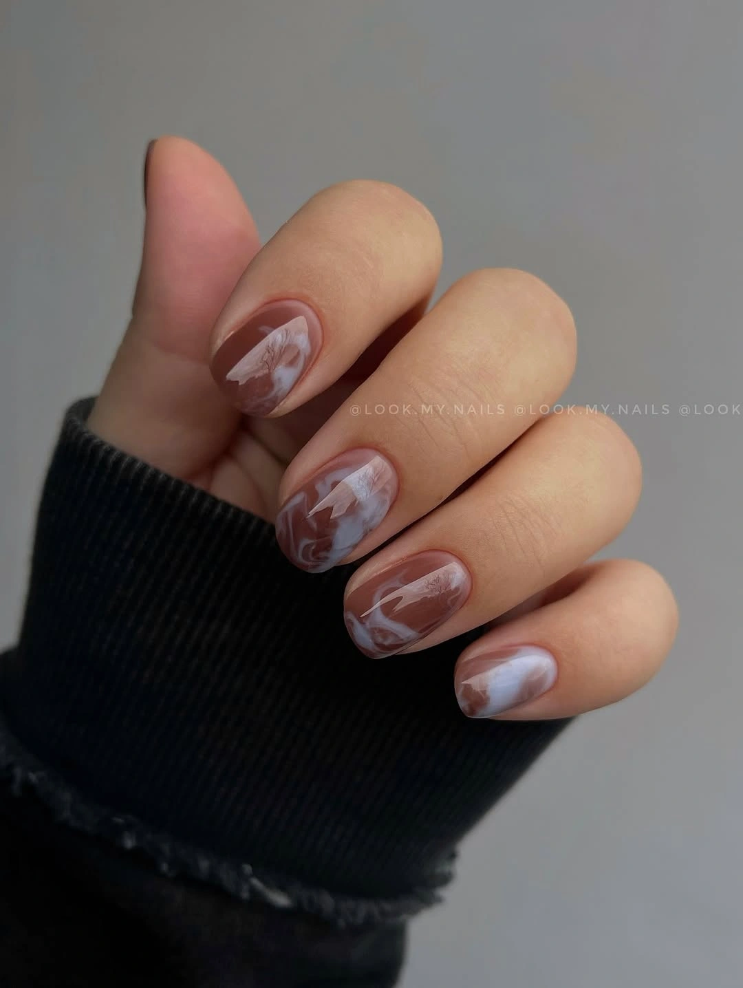 long almond nude nails with caramel brown curved accents