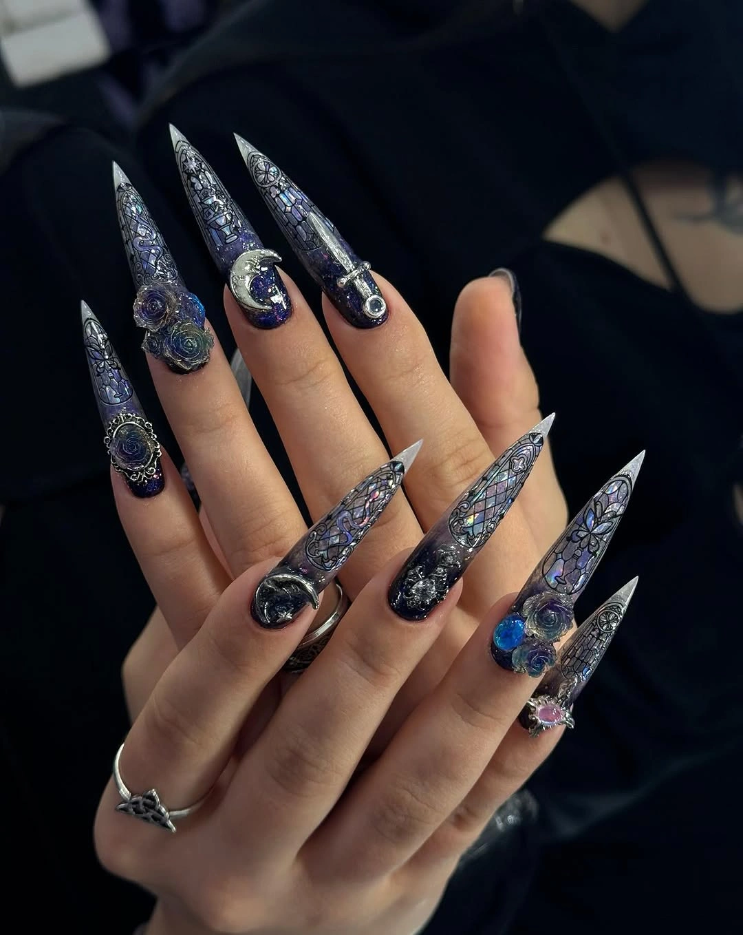 Extreme stiletto nails with dark glitter and reflective embellishment