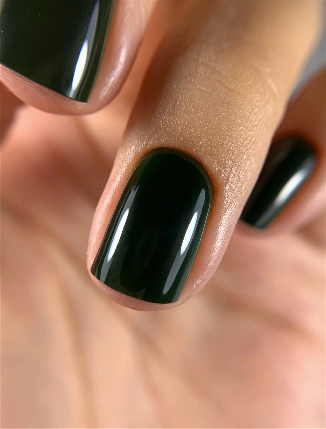 Short glossy forest-green nails with deep reflective color