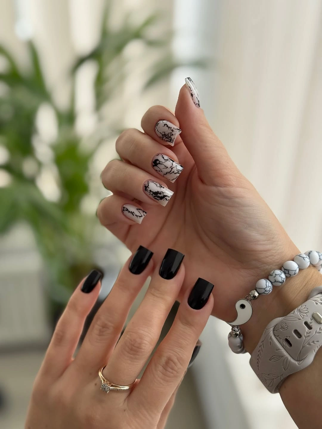Contrasting pale illustrated nails and black-tipped dark accents