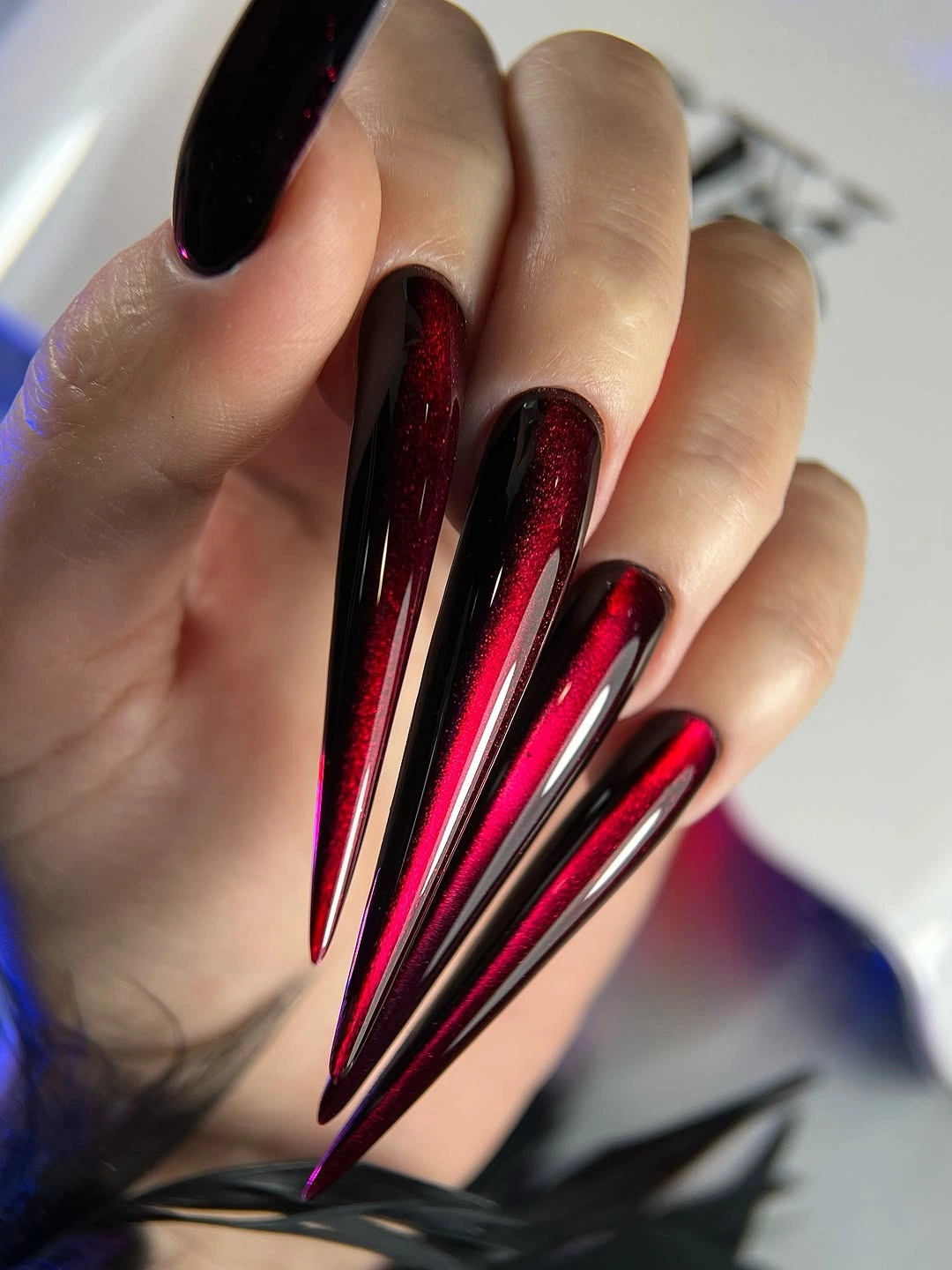 Extreme red-black stiletto nails with narrow reflective lines
