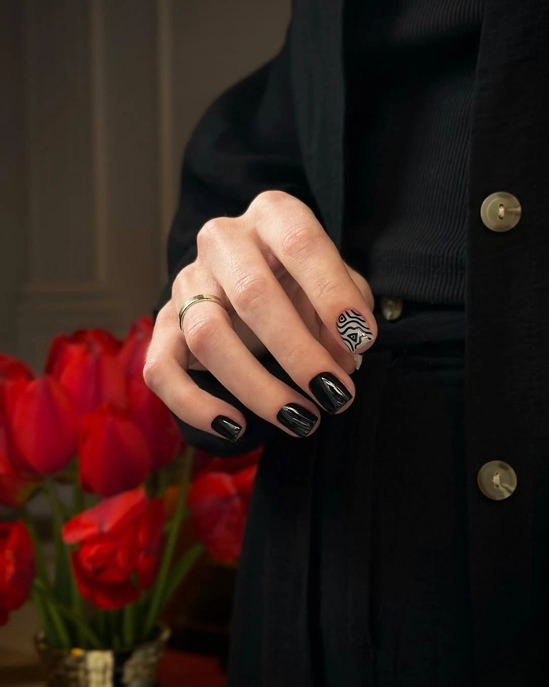 Short glossy black nails with one tiny contrasting accent