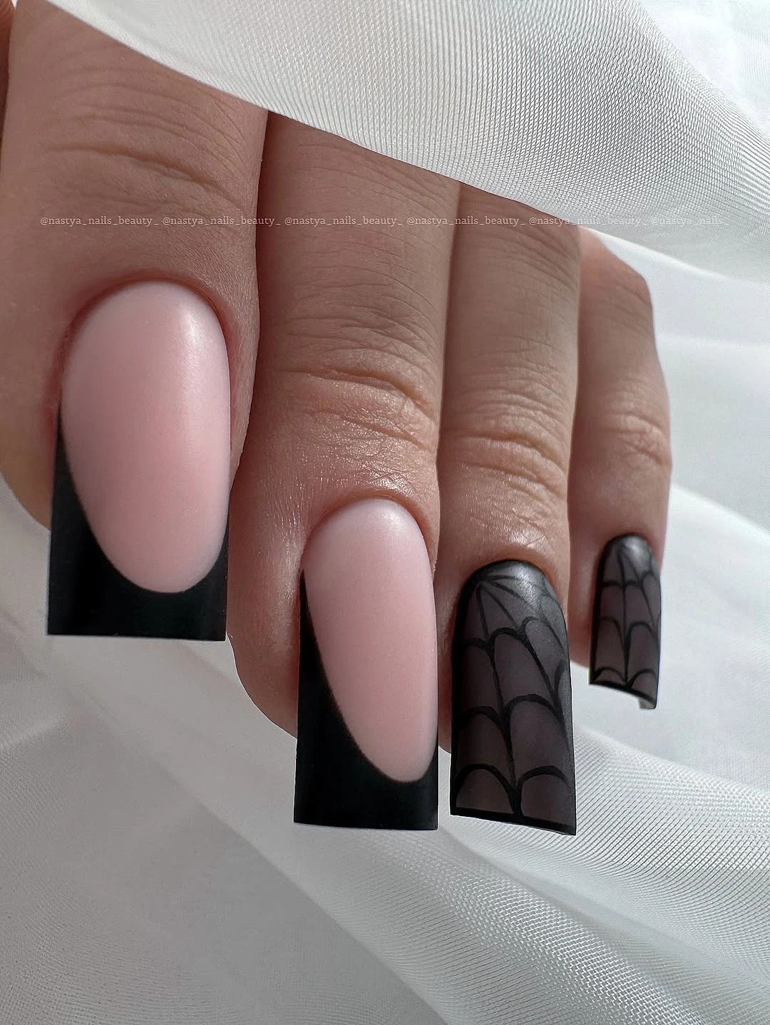 Long square pink nails with broad black French edges and curves