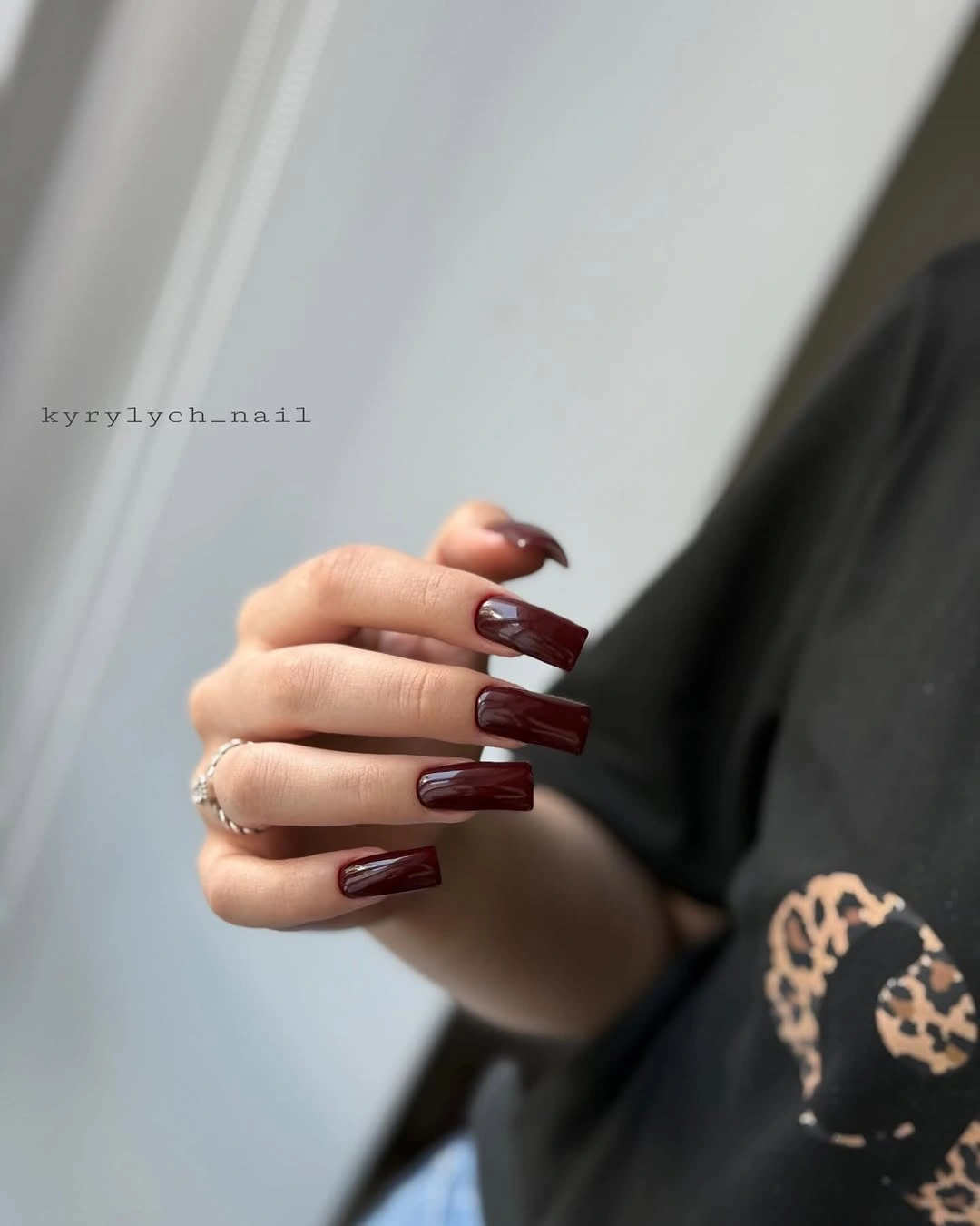 Medium dark cherry nails with one pale patterned accent