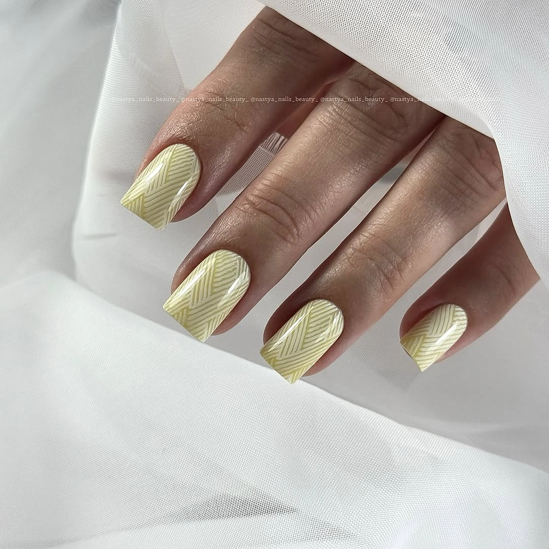 Long almond cream nails with subtle diagonal line texture