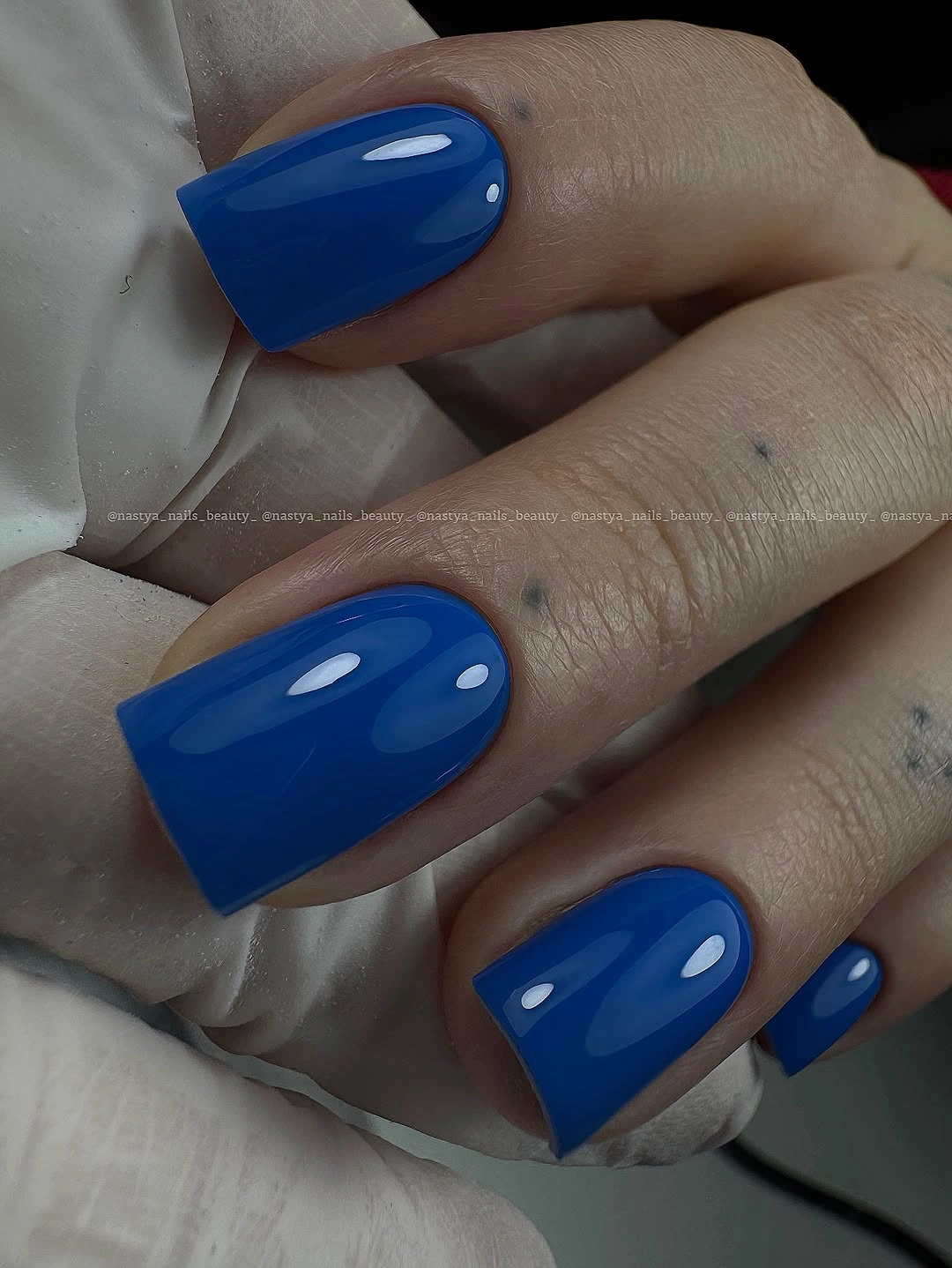 Medium-long glossy cobalt blue square nails with clean highlights