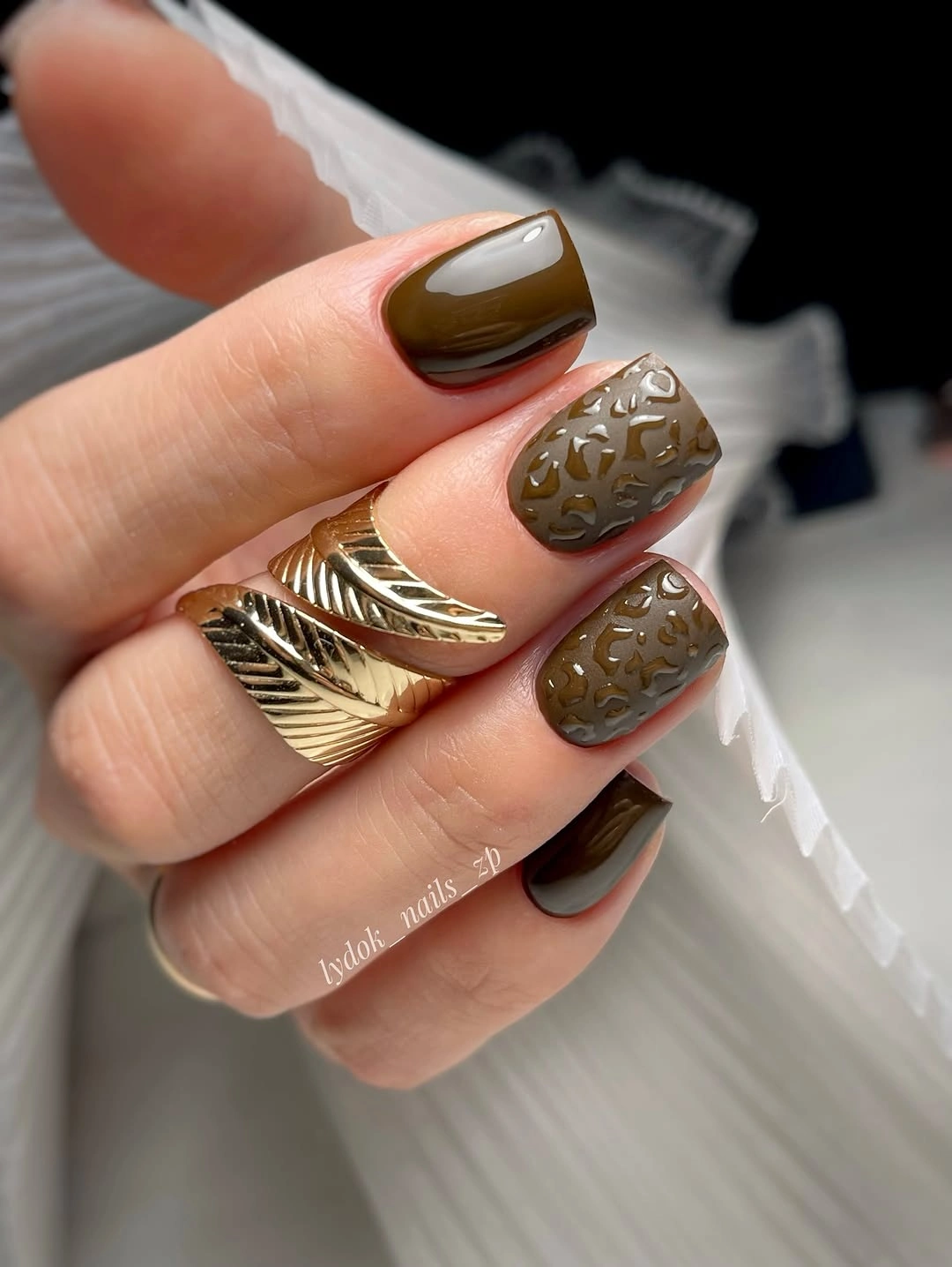 Short olive-brown nails with raised antique metallic accents