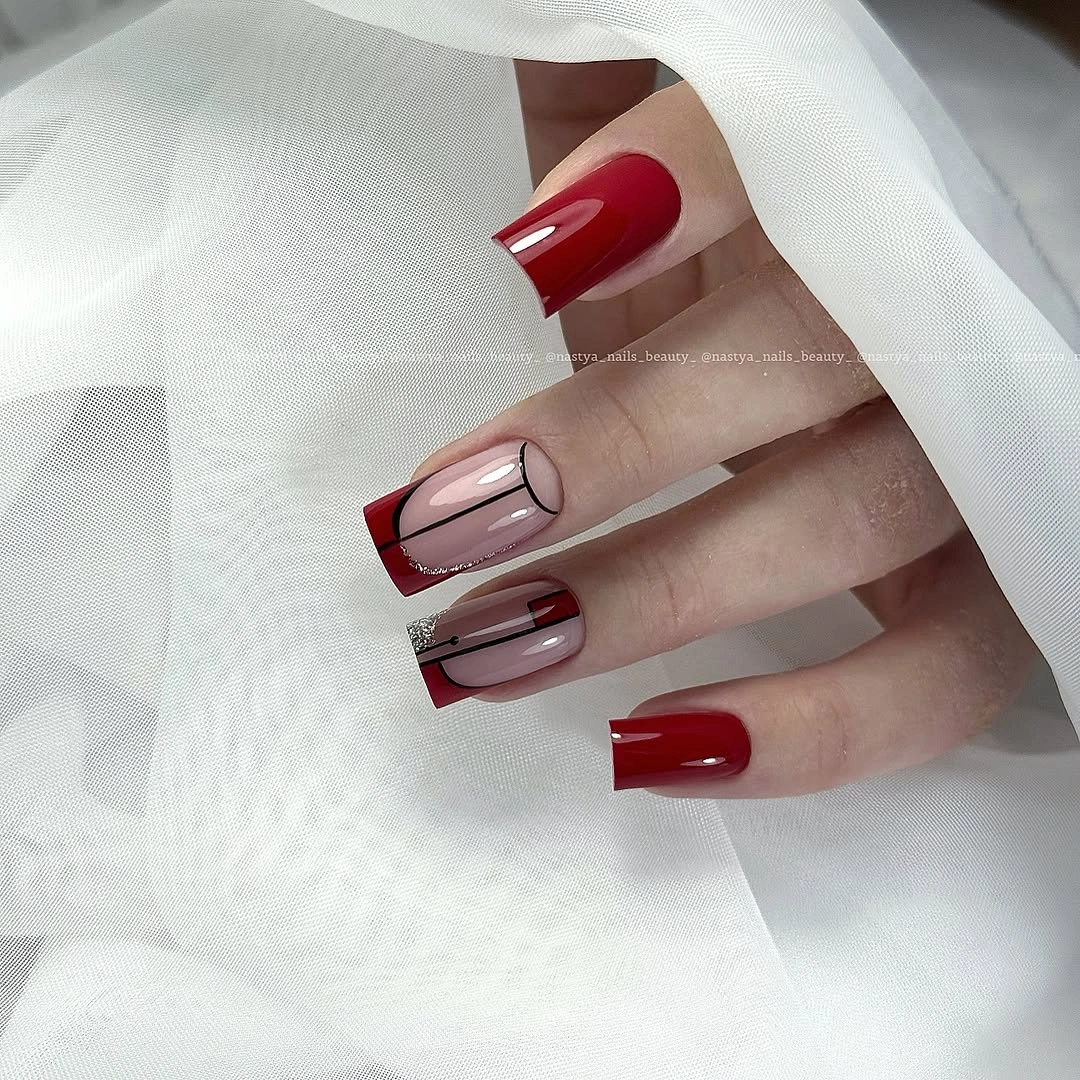 Long square nails with deep red French tips and one solid accent