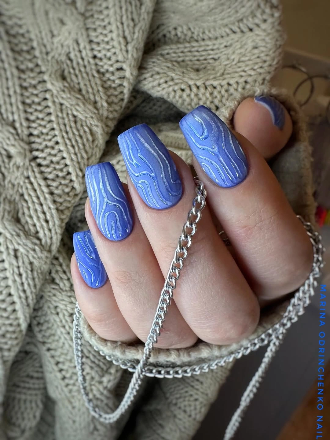Medium square blue nails with lighter raised wave lines