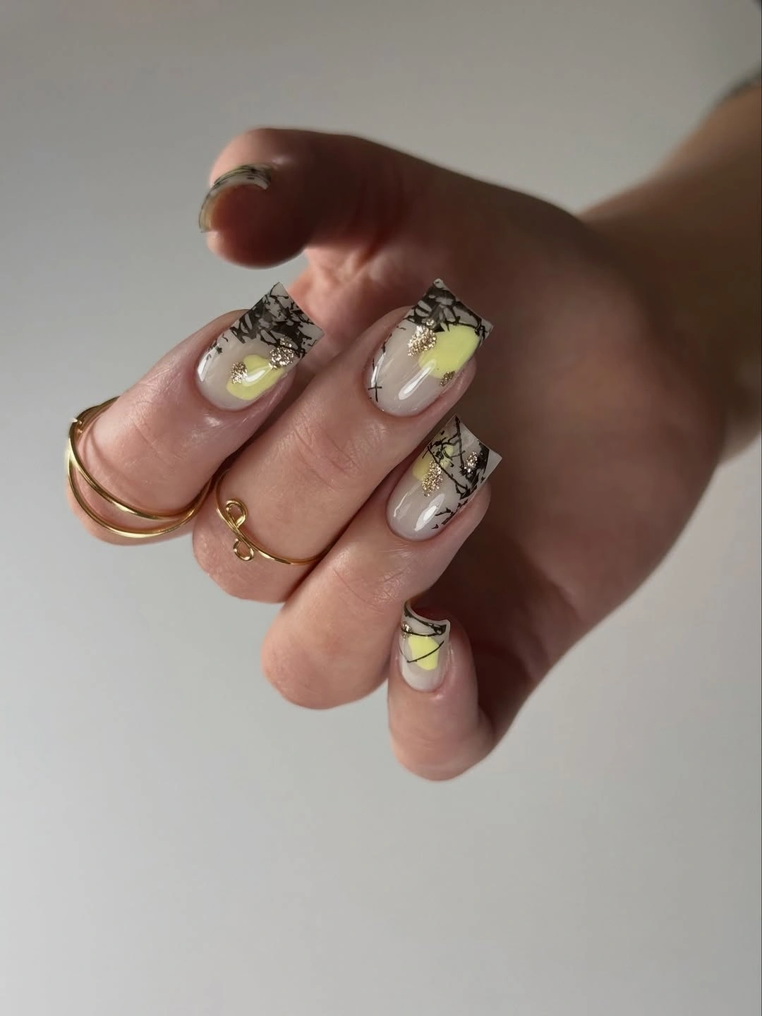 Medium square pale nails with yellow tips and black graphic accents