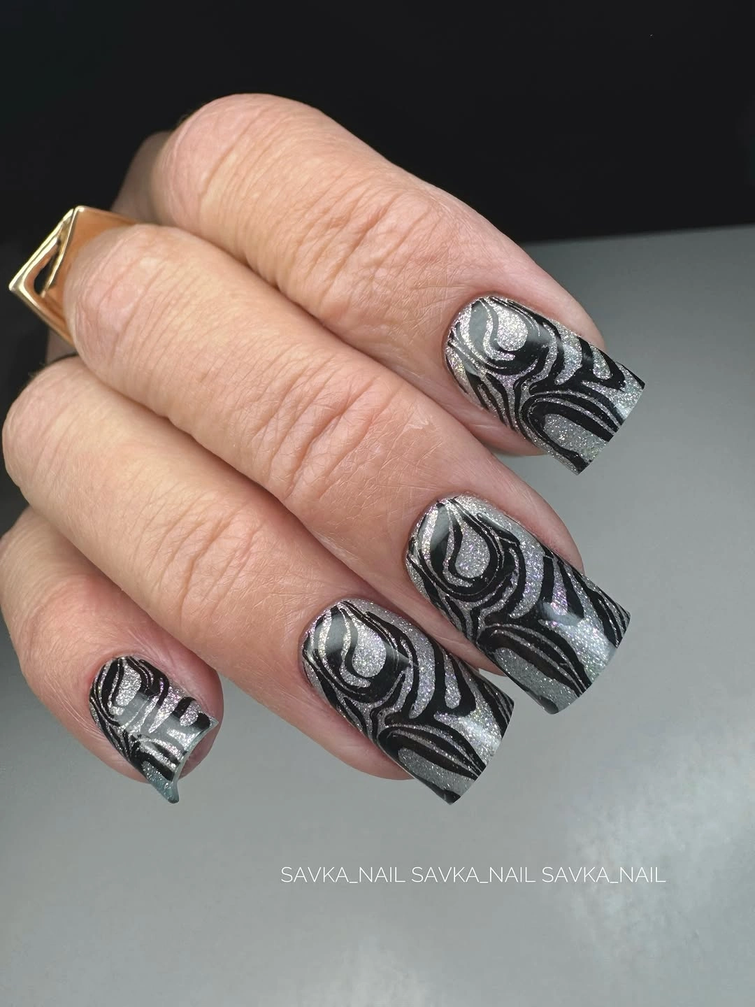 Short square silver nails with repeated black flowing lines