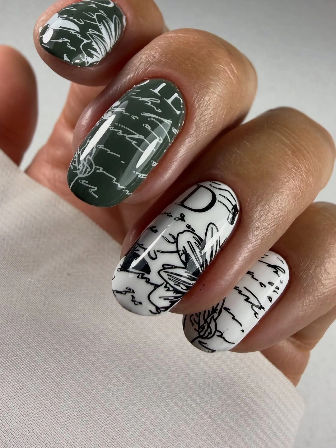Short oval forest green and white nails with sketch lines