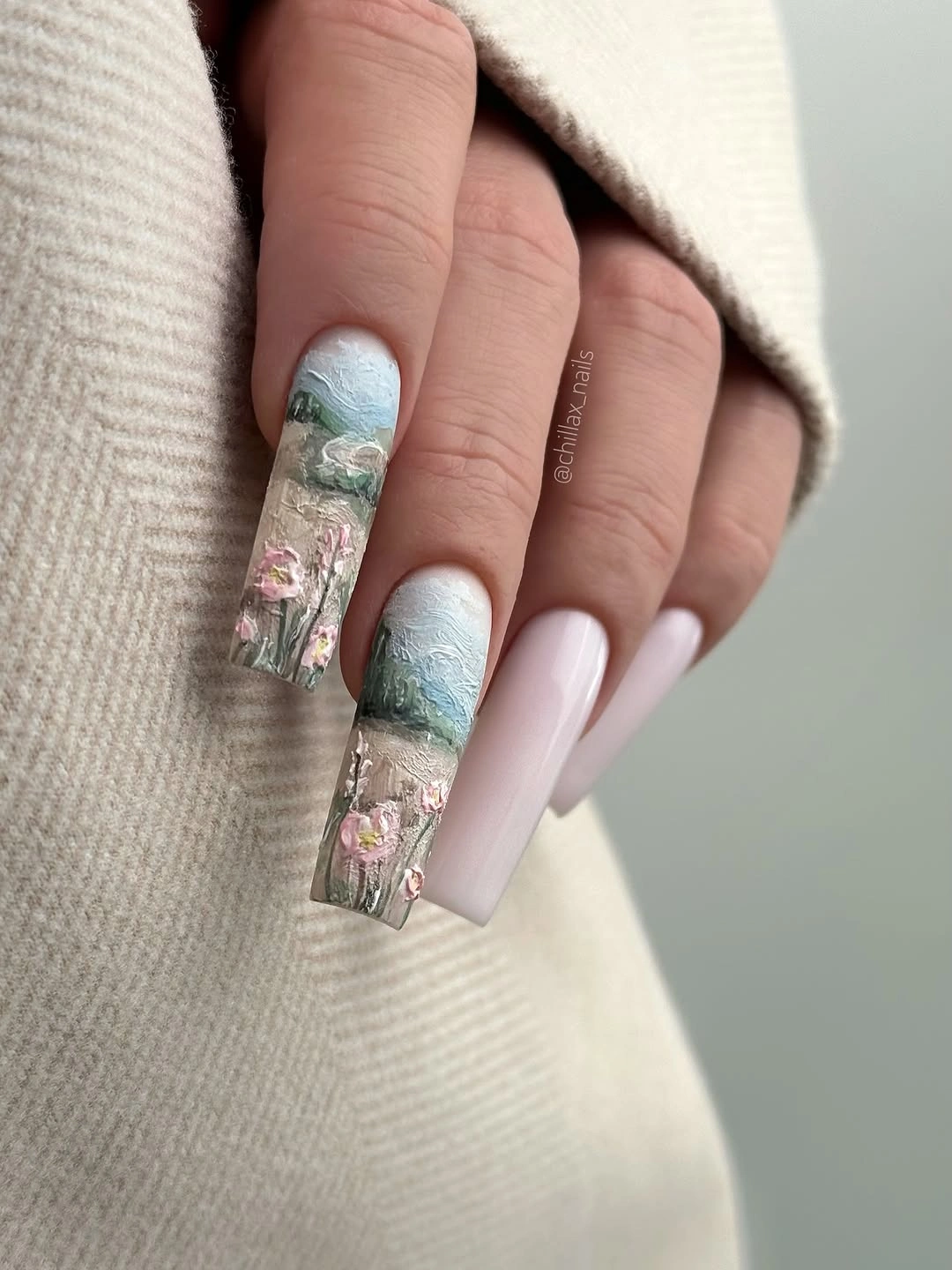 Long square translucent blue nails with floral and reflective accents