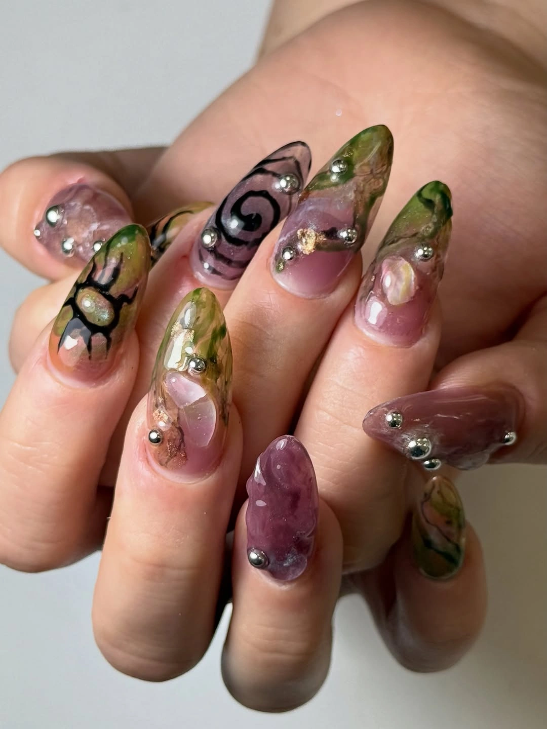 Long stiletto translucent nails with green purple and raised details