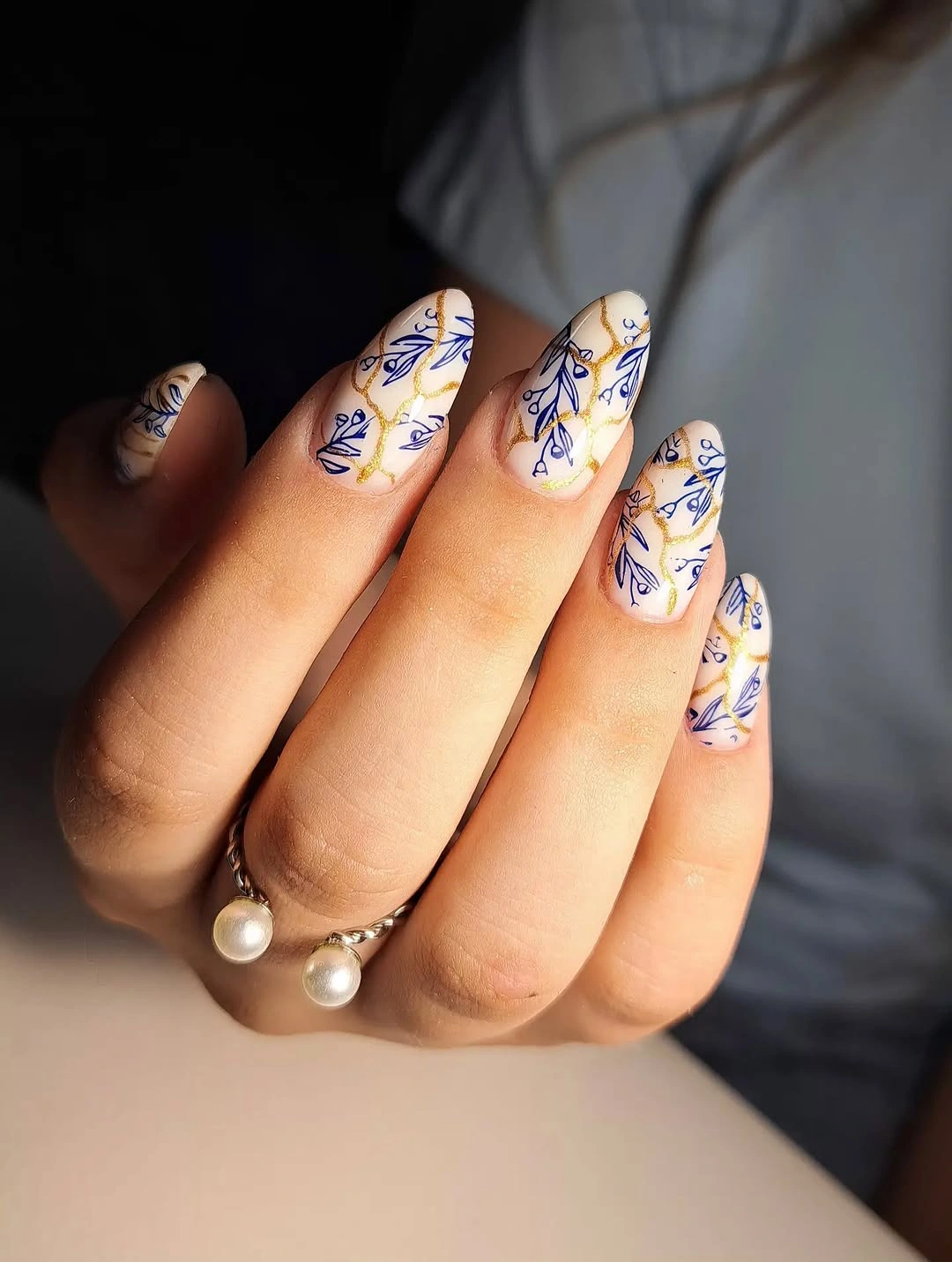Medium almond cream nails with delicate blue botanical lines