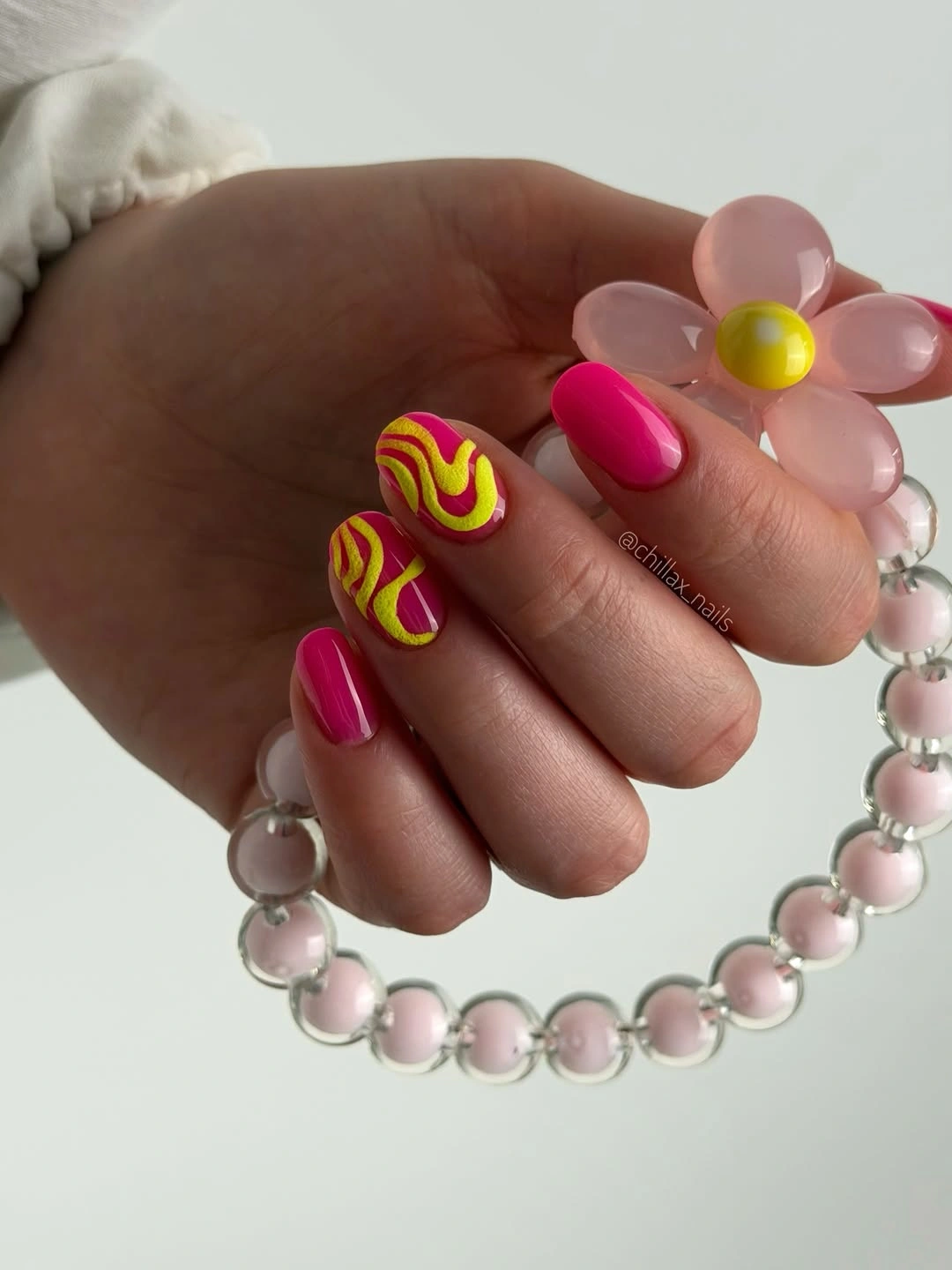 Medium rounded pink nails with yellow and lime wavy accents