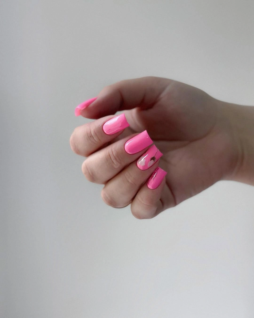 Hot pink short square nails with tiny floral accent