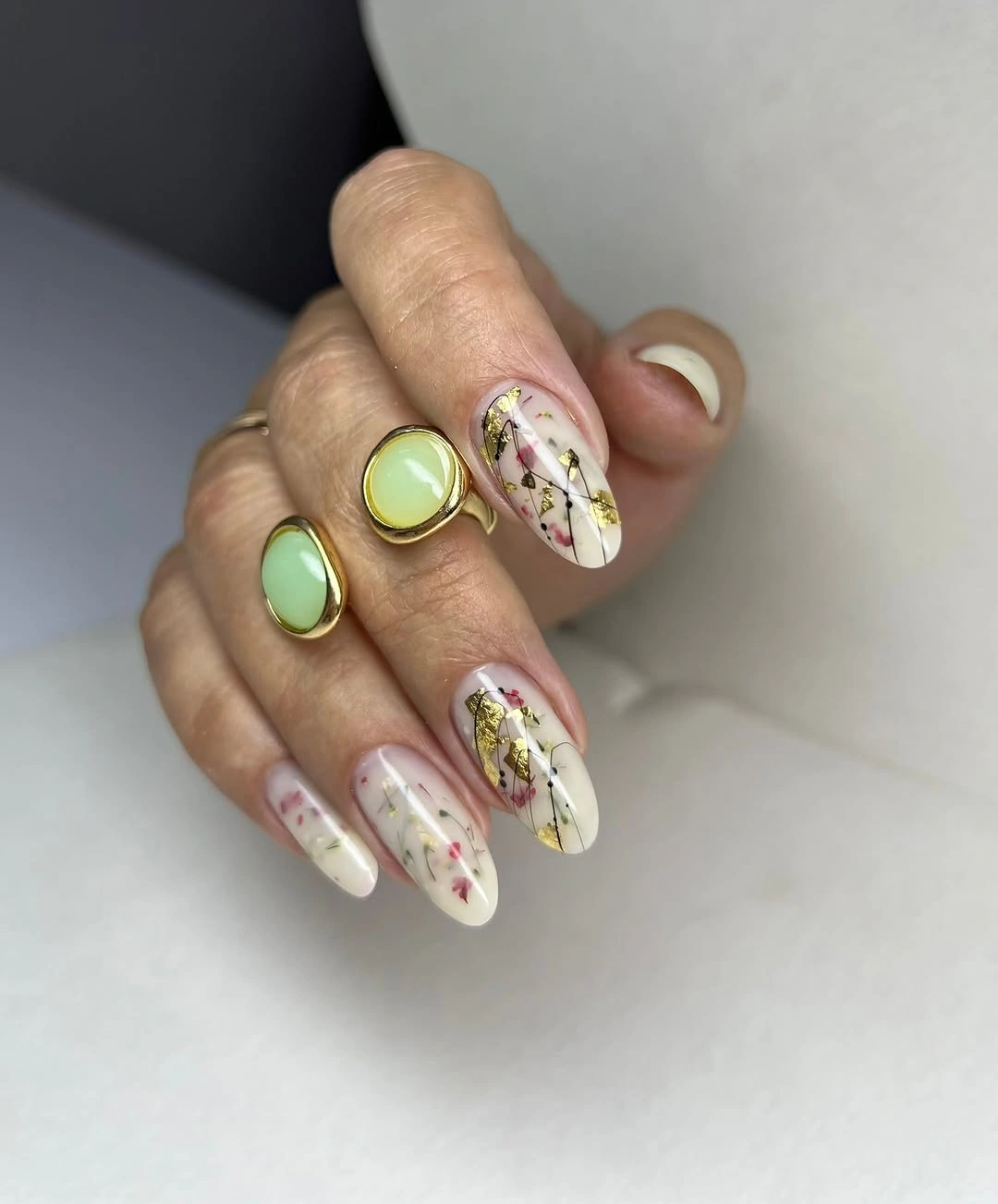 Milky botanical nails with irregular gold accents
