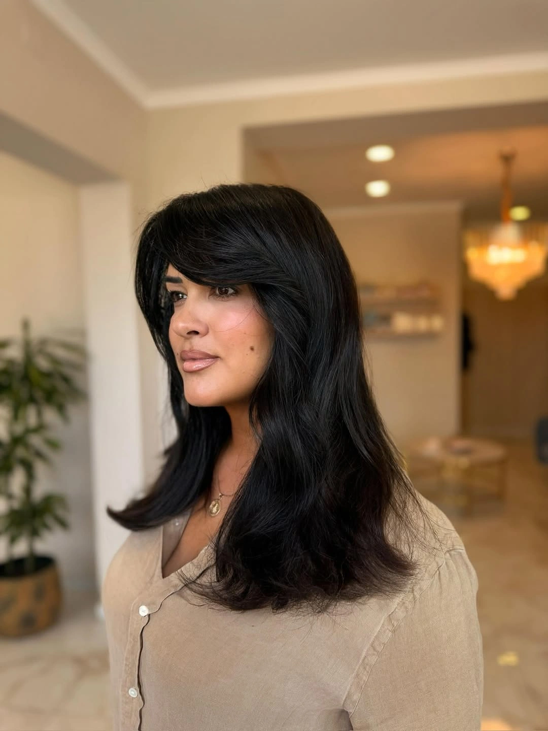 Medium long dark brown hair with feathered face framing layers