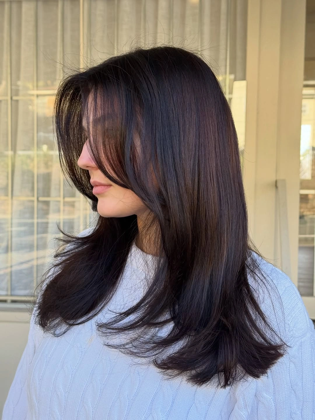 Medium long dark brown hair with curtain framing and feathered ends