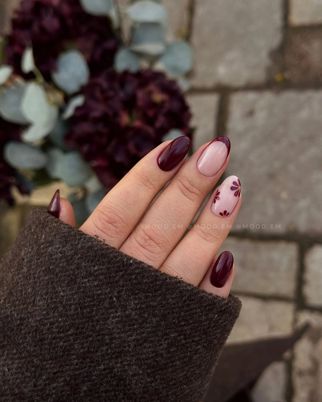 Medium almond burgundy nails with one dusty pink floral accent