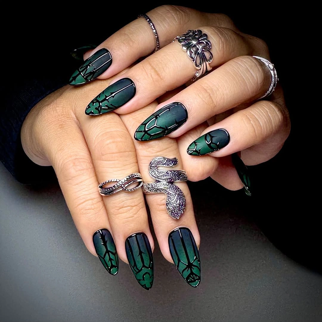Deep teal nails with repeating pale green segmented linework