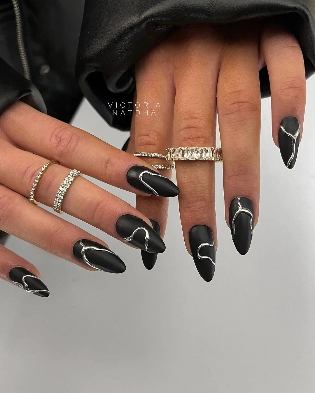 Matte black almond nails with thin silver curved lines
