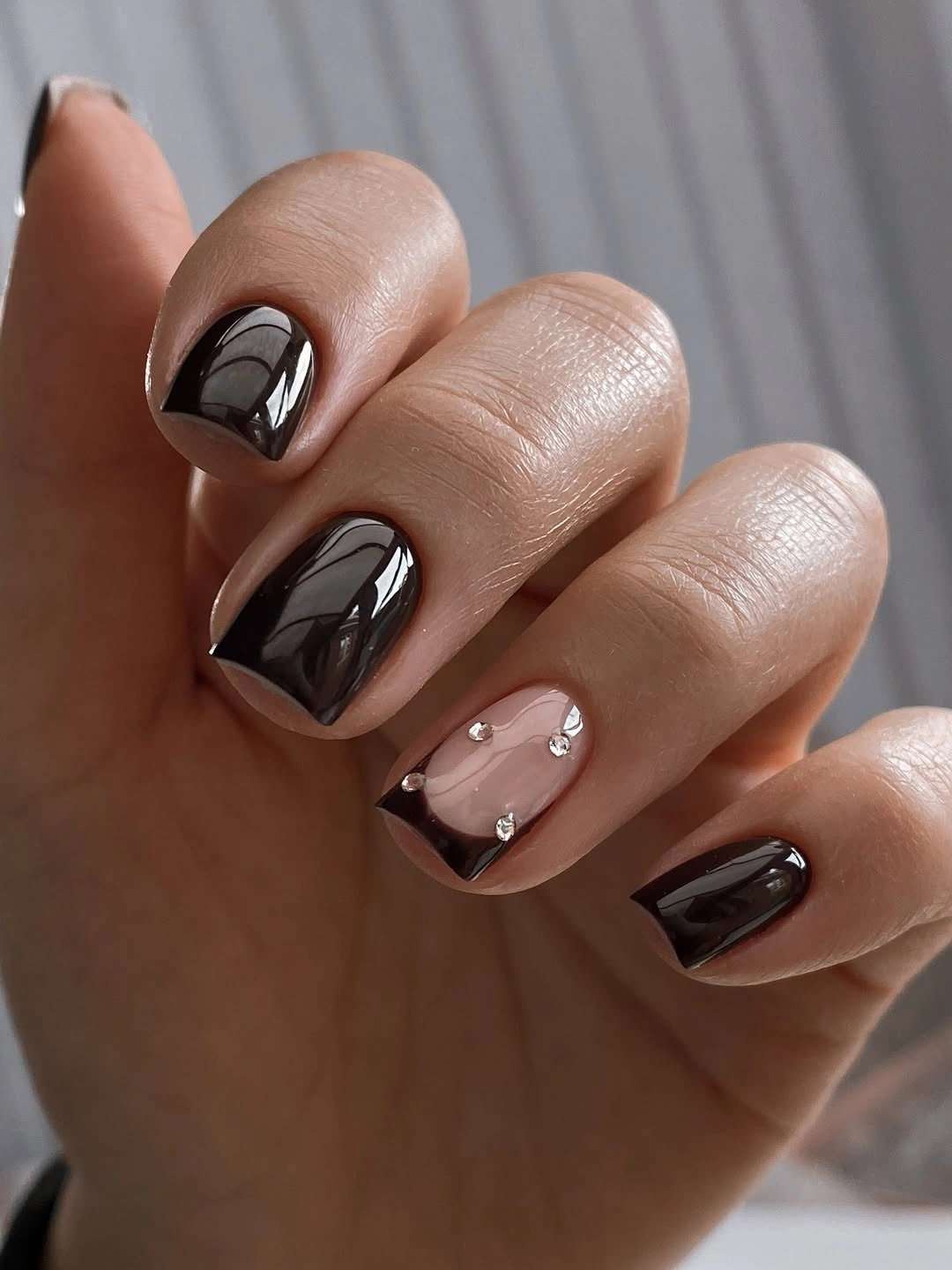 Short glossy espresso nails with one nude jeweled accent nail