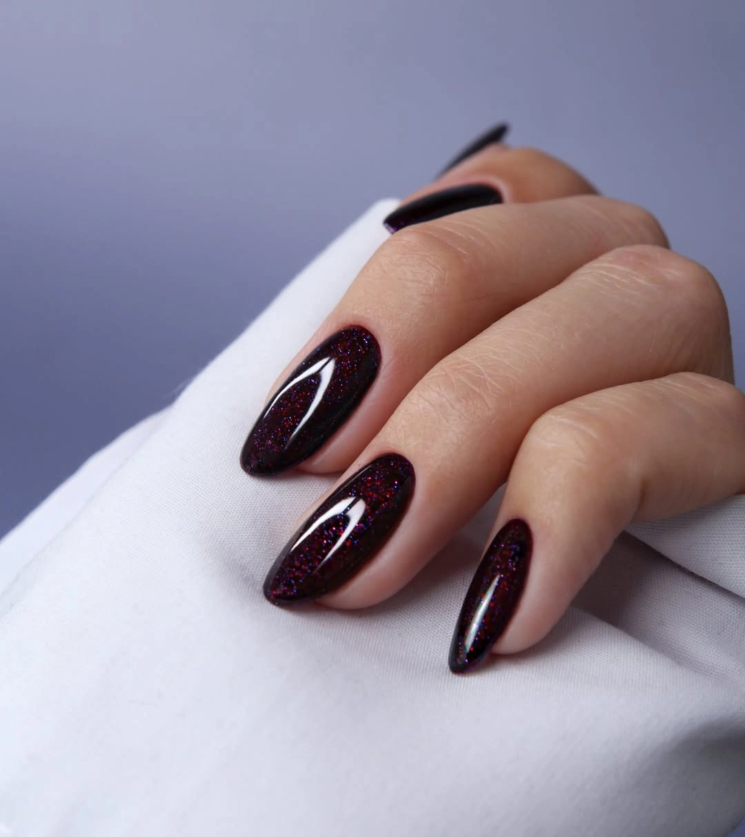 Glossy dark plum almond nails with restrained burgundy shimmer