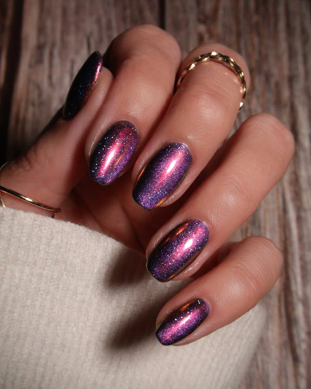 Short purple oval nails with a bright pink reflective center glow